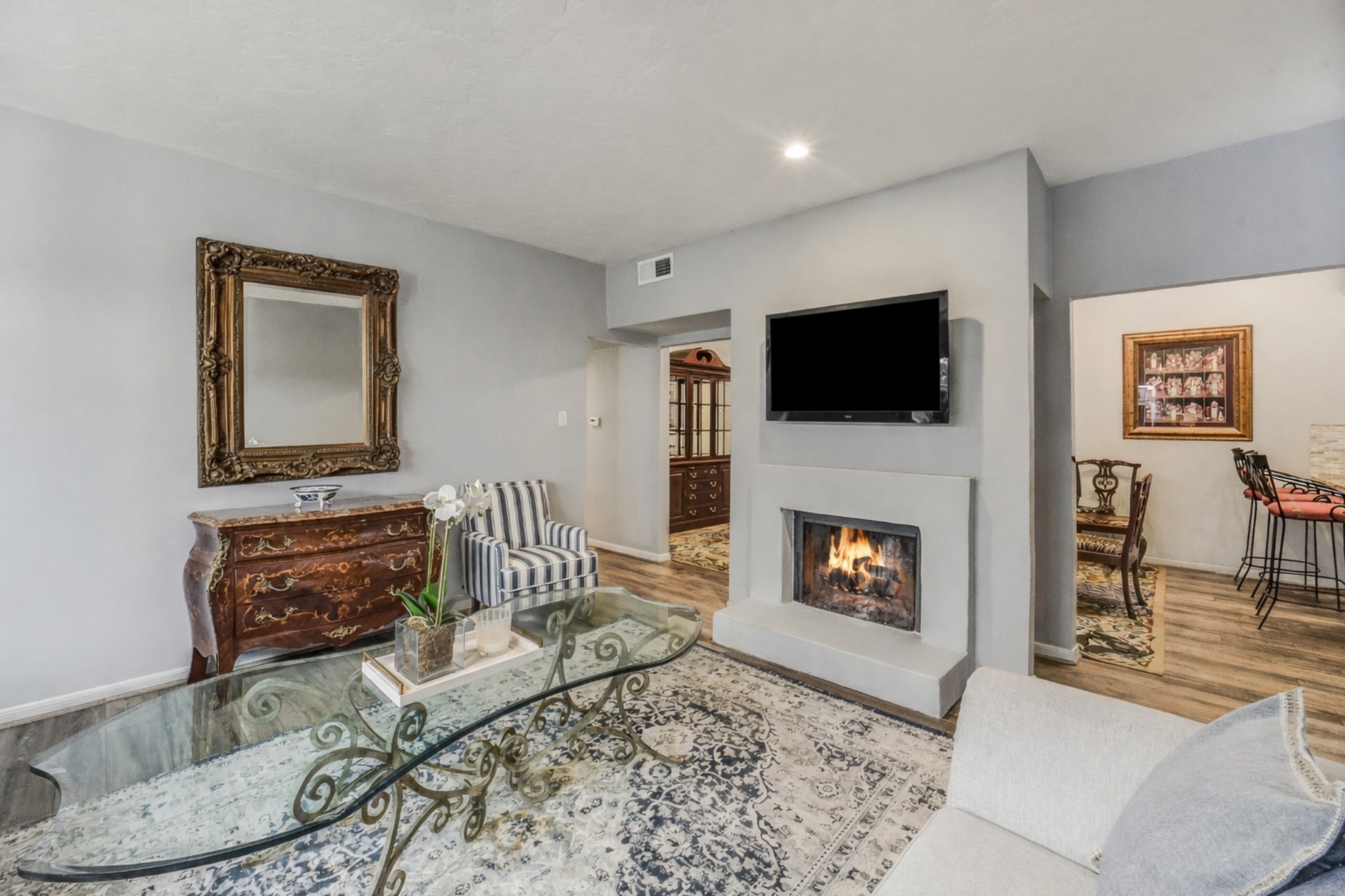 2100 Tanglewilde Street, Unit 591 Houston, TX 77063 - Photo 4 of 18 Spacious family room anchored by the wood-burning fireplace creates a warm focal point and comfortable gathering space. The open layout flows seamlessly into the dining and kitchen areas — ideal for everyday living and entertaining.