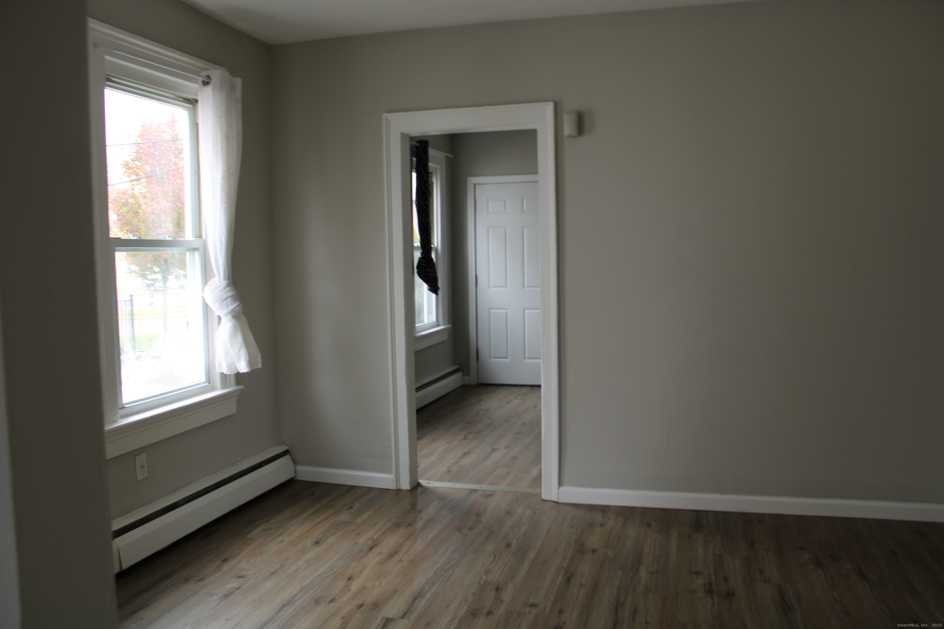 42 Summer Street, Unit 5 Bristol, CT 06010 - Photo 7 of 15 an empty room with wooden floor and windows