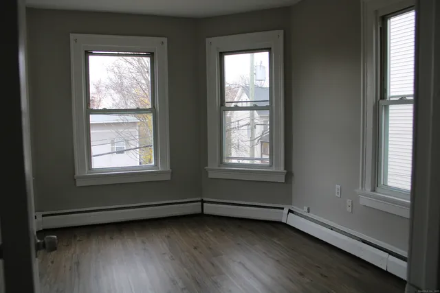 a view of a room with wooden floor and windows