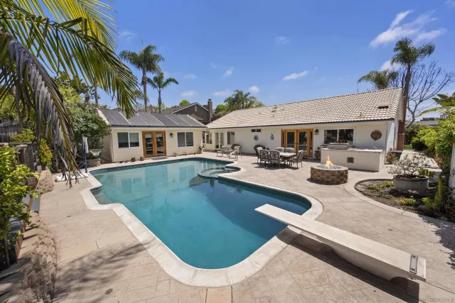 a view of a house with swimming pool and sitting area