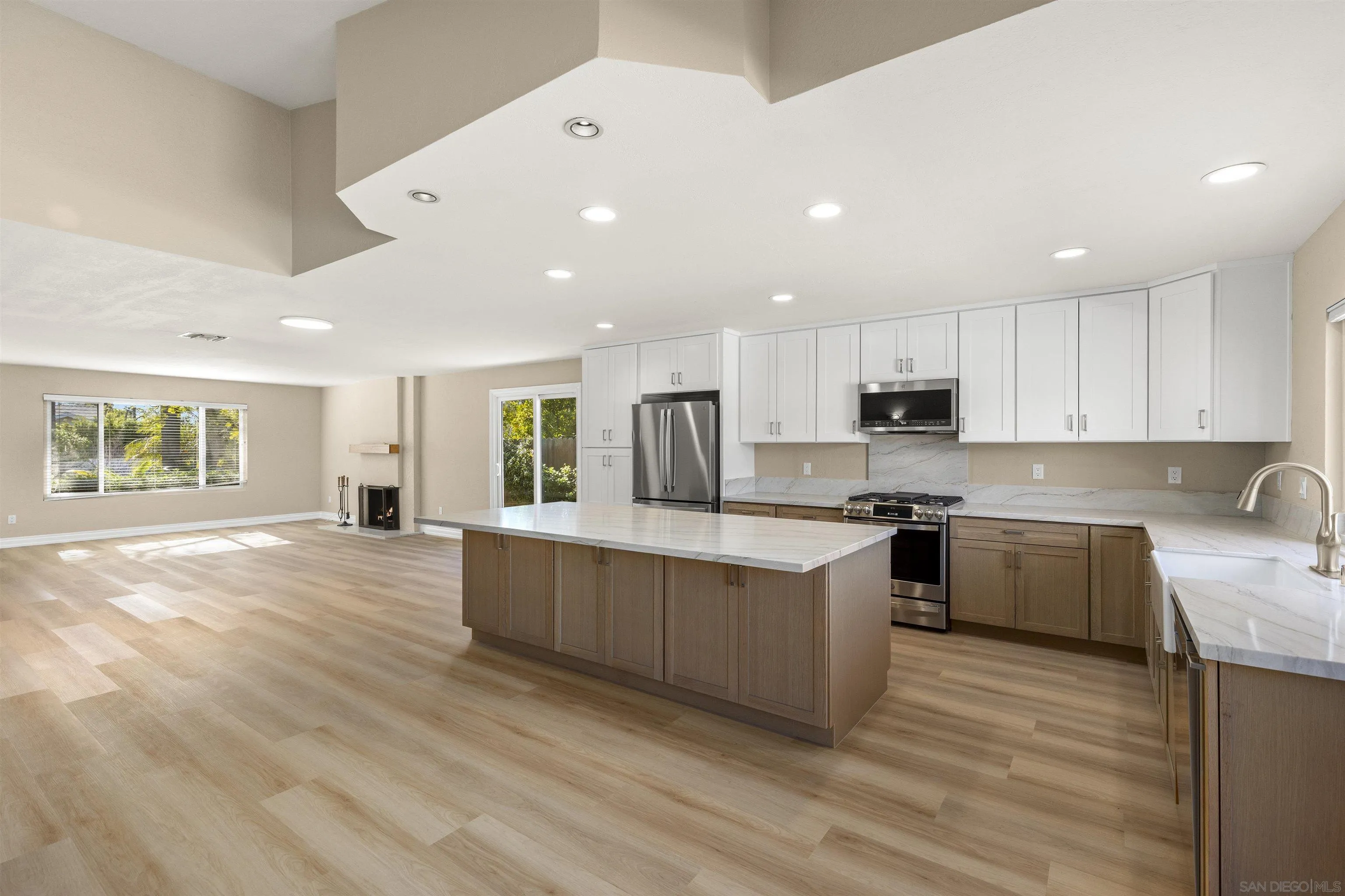 1510 Orangeview Drive, Unit 12 Encinitas, CA 92024 - Photo 10 of 55 a large kitchen with stainless steel appliances granite countertop a stove a sink a refrigerator and white cabinets with wooden floor