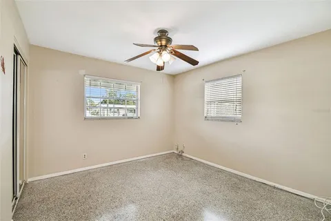 an empty room with a window and a ceiling fan