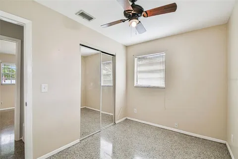 an empty room with windows and fan