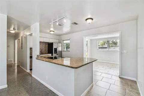 a view of a hallway with wooden floor and a living room