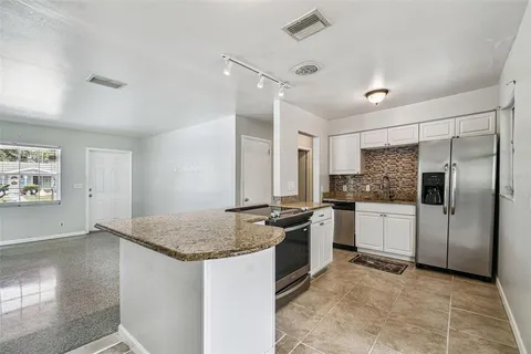 a kitchen with stainless steel appliances granite countertop a stove and a refrigerator