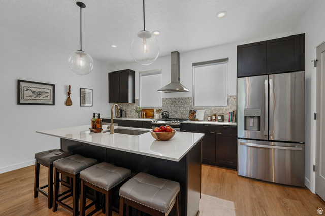 493 East Alice Way Layton, UT 84041 - Photo 6 of 31 Kitchen featuring stainless steel appliances, decorative light fixtures, light wood-type flooring, dual tone cabinets, and a center island with sink