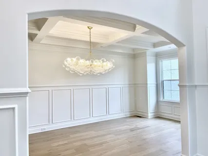 an empty room with wooden floor ceiling fan and windows