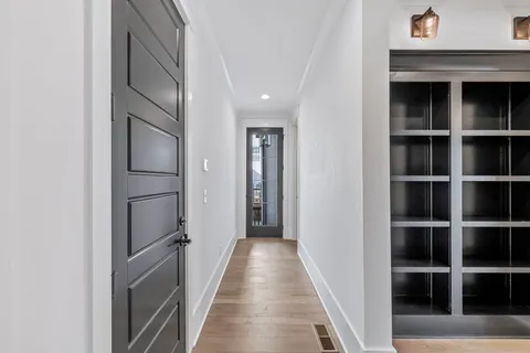a view of an empty room with wooden floor and staircase