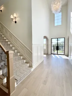 a view of an empty room with wooden floor fireplace and a window