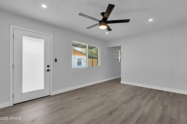 a view of a livingroom with a ceiling fan and wooden floor
