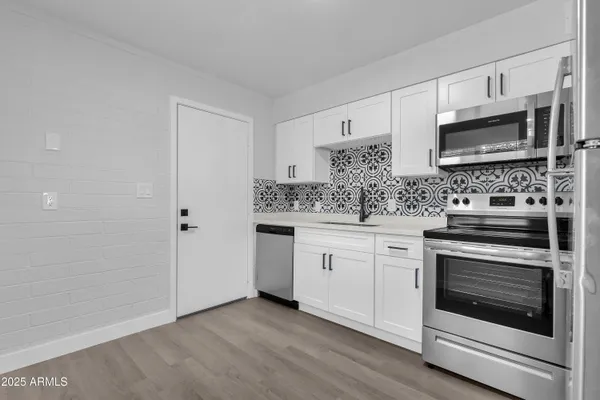 a kitchen with stainless steel appliances granite countertop a stove microwave and sink