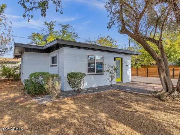 a front view of a house with a yard and potted plants