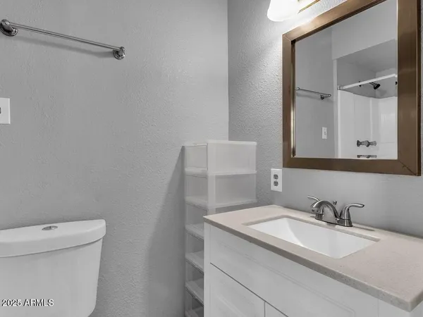 a bathroom with a granite countertop sink and a toilet