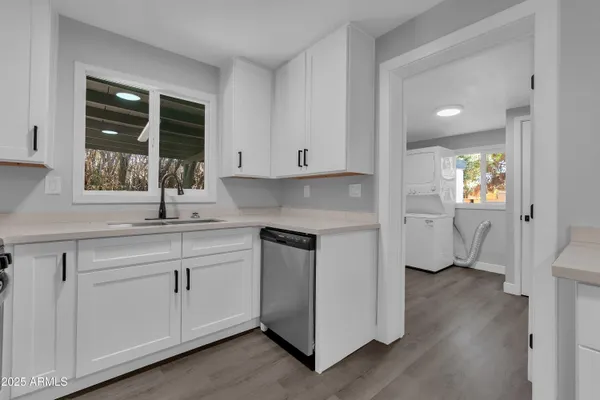 a kitchen with white cabinets and sink