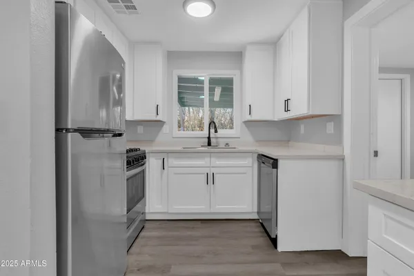 a kitchen with stainless steel appliances granite countertop a sink stove and refrigerator