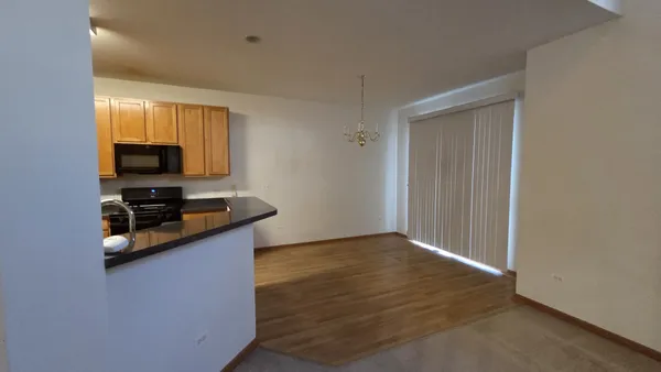a kitchen with granite countertop white cabinets and black appliances