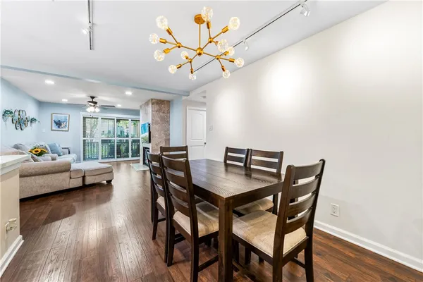 a kitchen with kitchen island a dining table chairs and a wooden floor