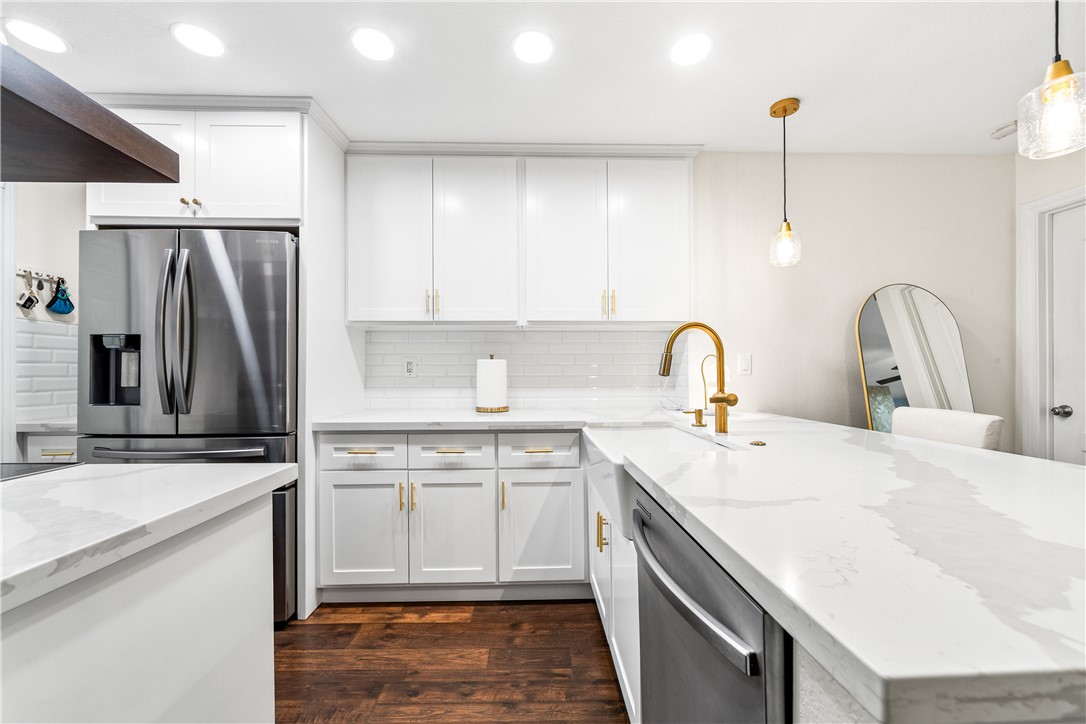 7890 East Spring Street Long Beach, CA 90815 - Photo 16 of 59 a kitchen with a sink a refrigerator and cabinets