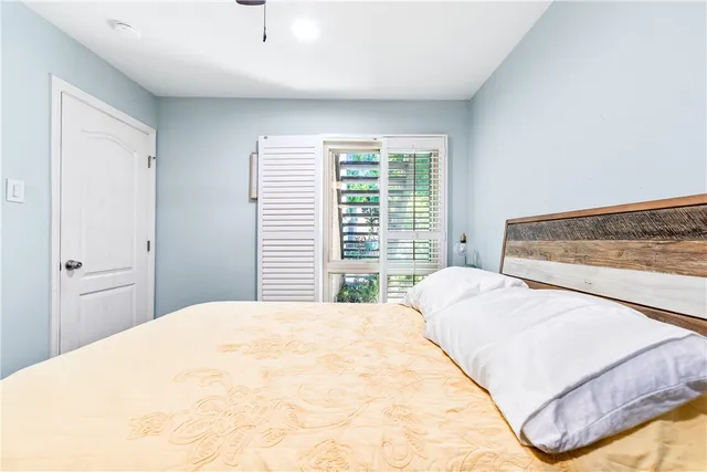 an empty room with wooden floor chandelier fan and windows