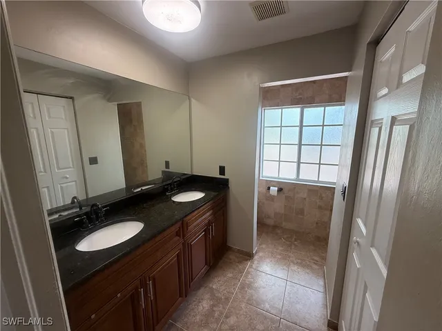 a bathroom with a granite countertop sink and a mirror
