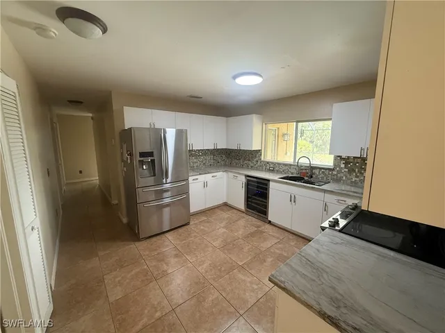 a large kitchen with a refrigerator a sink a stove a microwave and cabinets