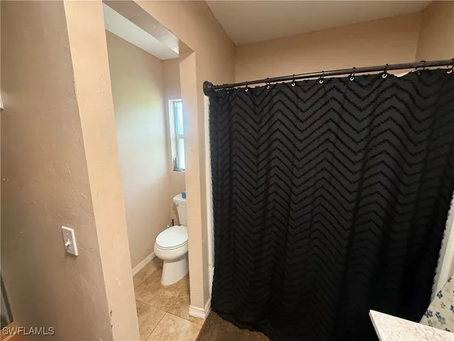 a bathroom with a shower curtain and a toilet