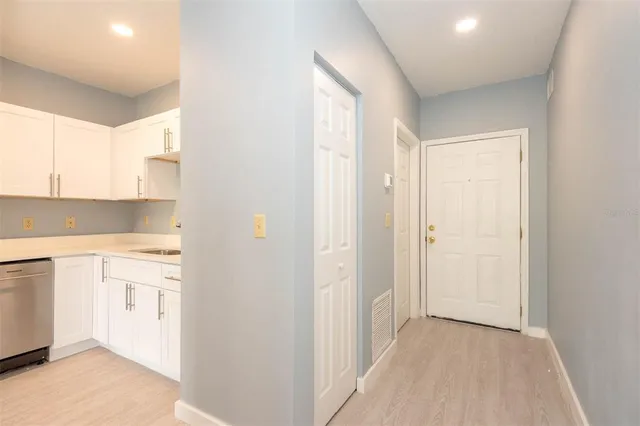 a view of a kitchen with white cabinets and a refrigerator