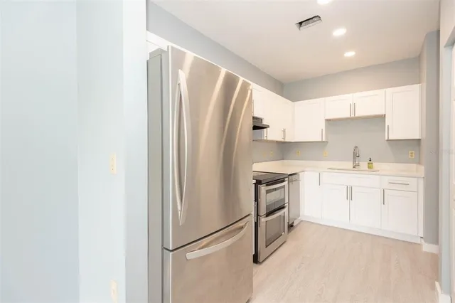 a kitchen with white cabinets and white appliances