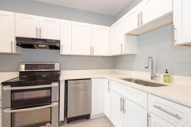 a kitchen with cabinets appliances a sink and a window