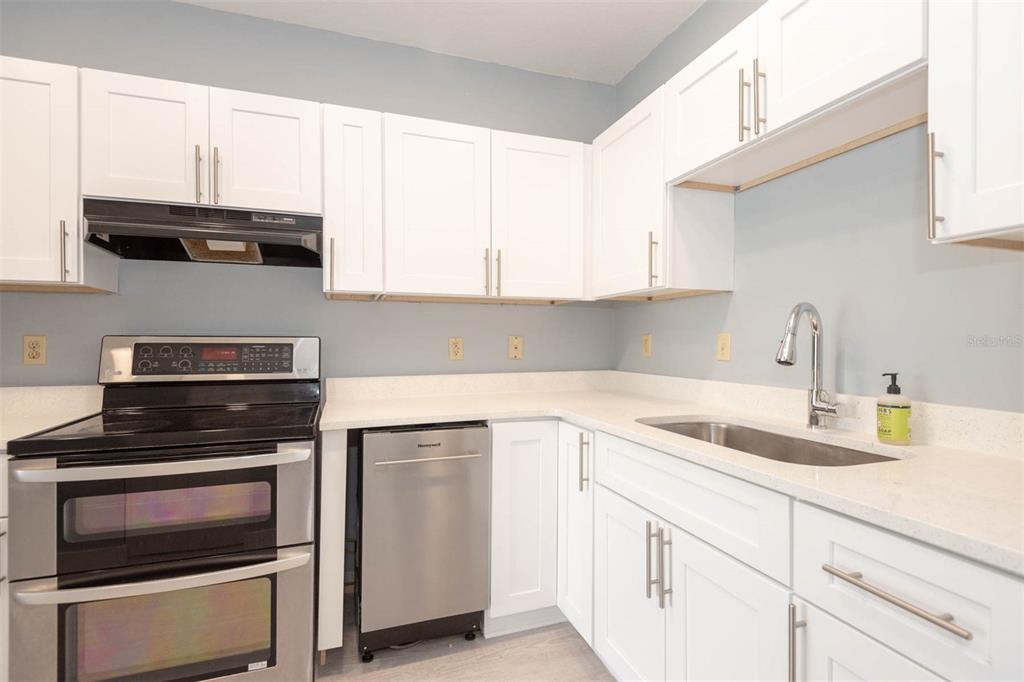 946 15th Street, Unit 202 Daytona Beach, FL 32117 - Photo 20 of 40 a kitchen with cabinets appliances a sink and a window