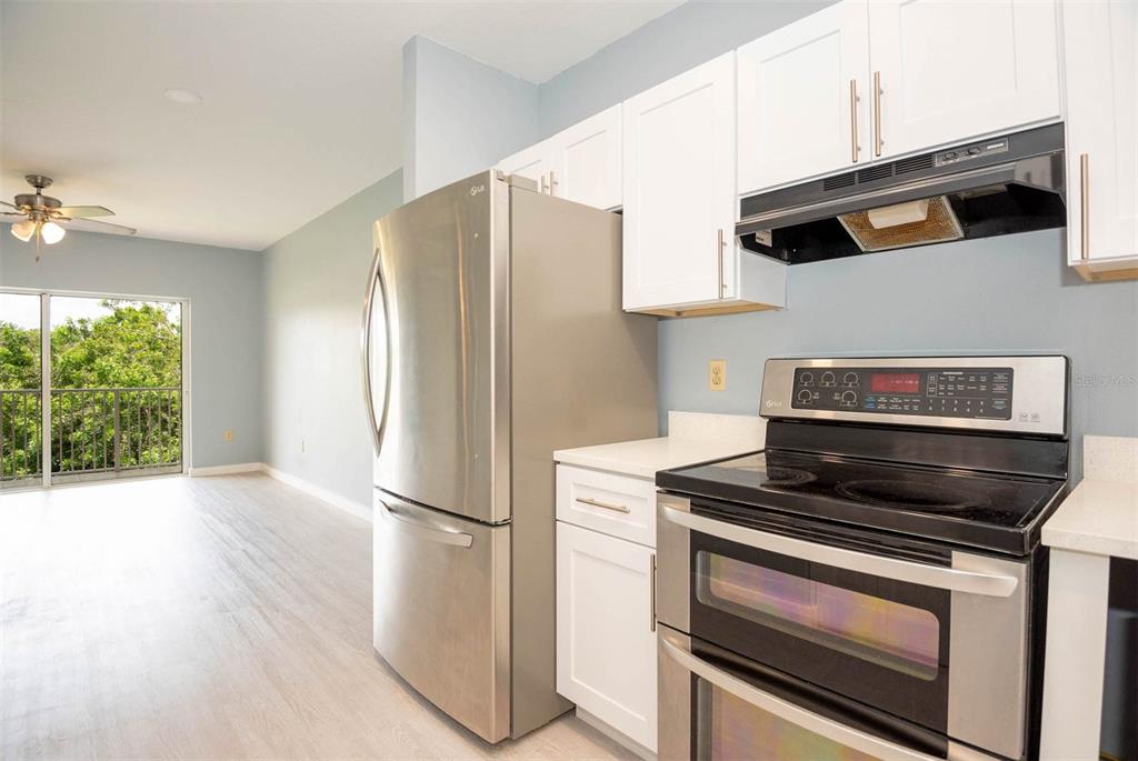 946 15th Street, Unit 202 Daytona Beach, FL 32117 - Photo 22 of 40 a kitchen with stainless steel appliances a stove a microwave and a refrigerator