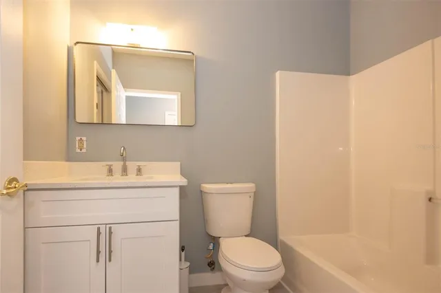 a bathroom with a toilet a sink a vanity and mirror