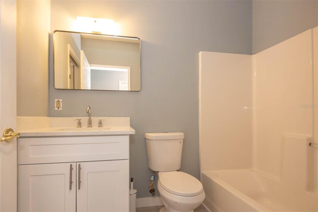 946 15th Street, Unit 202 Daytona Beach, FL 32117 - Photo 23 of 40 a bathroom with a toilet a sink a vanity and mirror