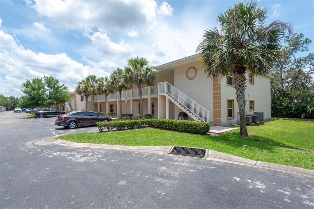946 15th Street, Unit 202 Daytona Beach, FL 32117 - Photo 3 of 40 a front view of a house with garden and trees