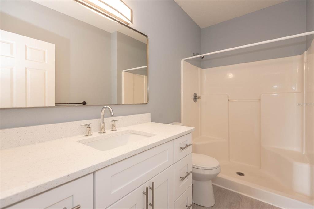 946 15th Street, Unit 202 Daytona Beach, FL 32117 - Photo 33 of 40 a bathroom with a sink a toilet a shower and a mirror