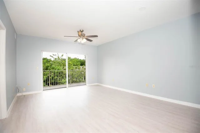 an empty room with a window and a ceiling fan