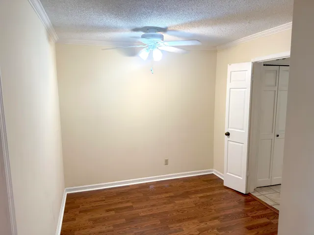 a view of empty room with wooden floor