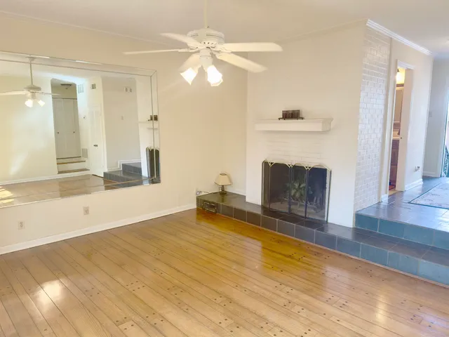 a view of empty room with wooden floor and fireplace