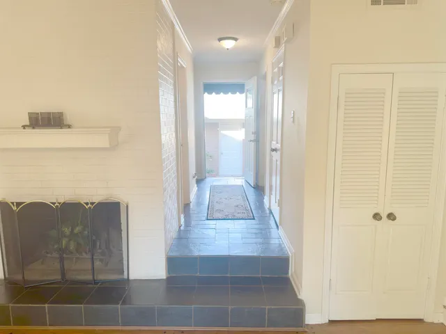 a view of a hallway with wooden floor and staircase