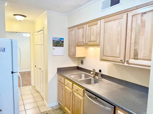 a kitchen with stainless steel appliances a sink a refrigerator a window and cabinets