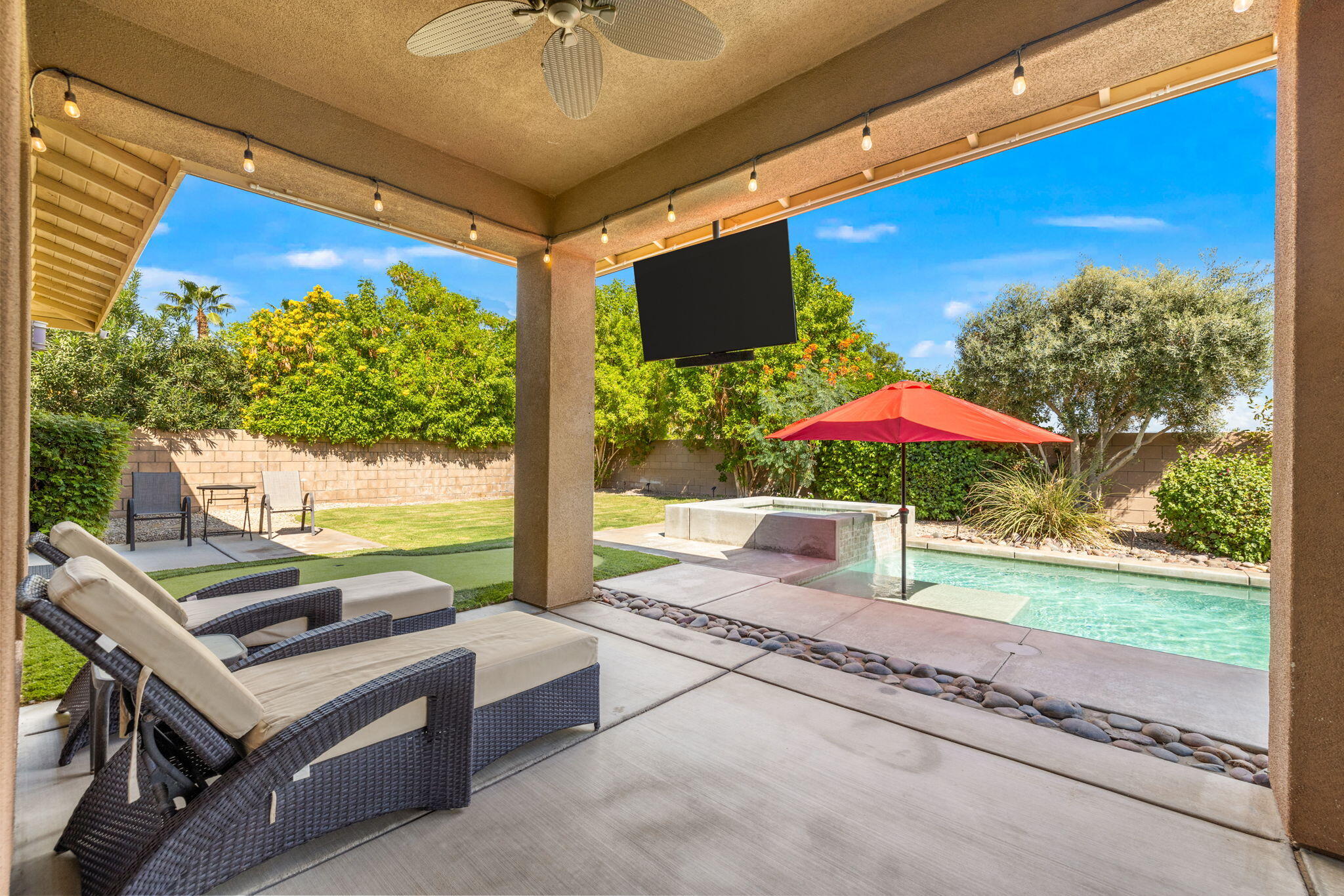 41252 Gaslight Avenue Bermuda Dunes, CA 92203 - Photo 32 of 37 a view of a patio with a table and chairs under an umbrella