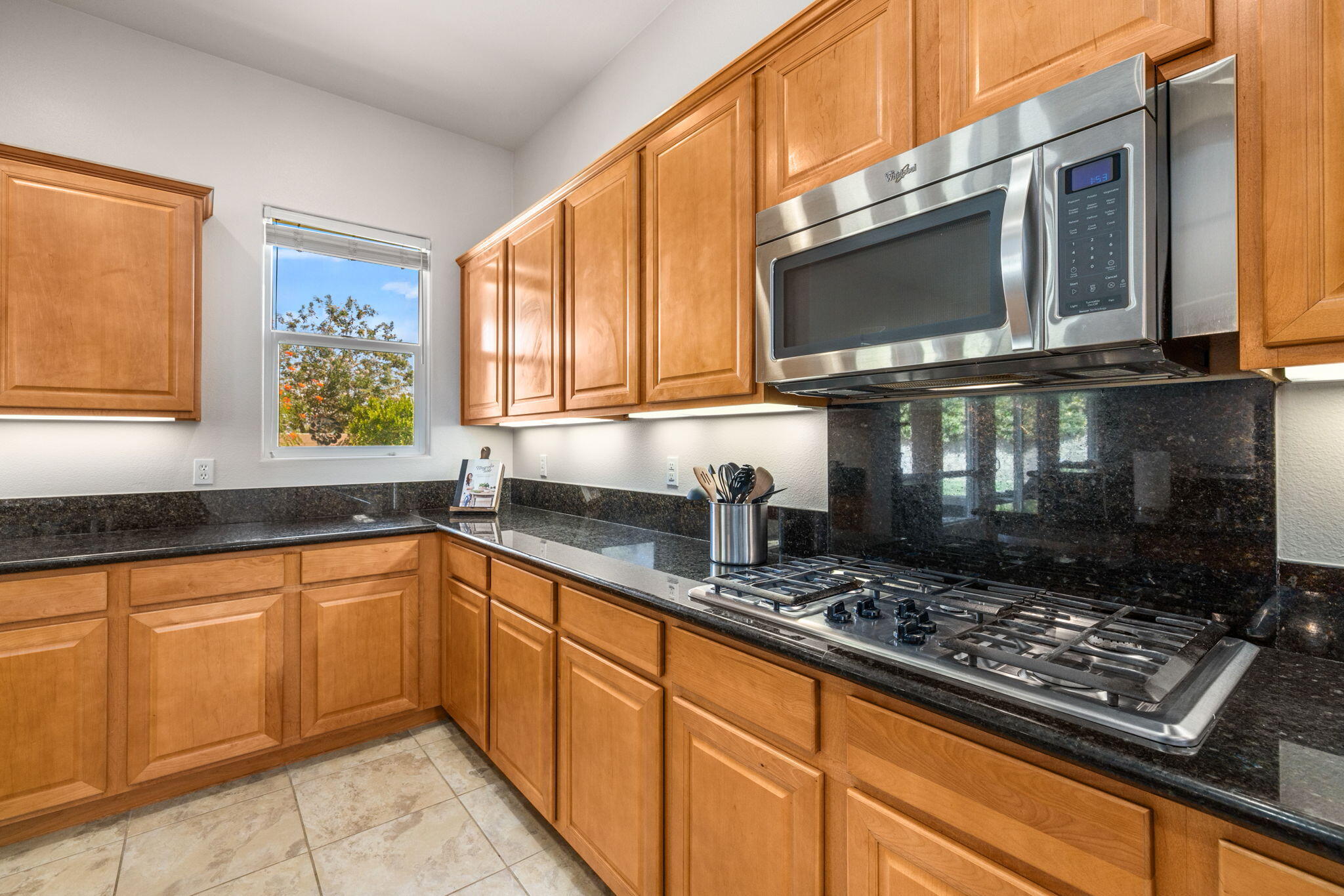 41252 Gaslight Avenue Bermuda Dunes, CA 92203 - Photo 9 of 37 a kitchen with stainless steel appliances a stove a microwave and sink