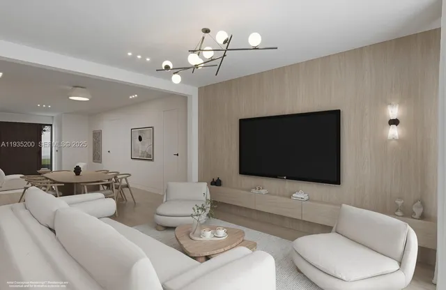 a living room with furniture a flat screen tv and kitchen view