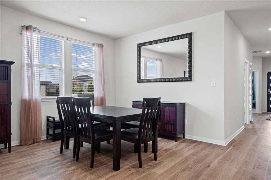 158 Gullivers Drive Elgin, TX 78621 - Photo 12 of 36 Right across from the island is your dedicated dining space. What’s great about this setup is how flexible it is. You can see they easily have a six-person table here, but you could definitely expand it for larger holiday gatherings.