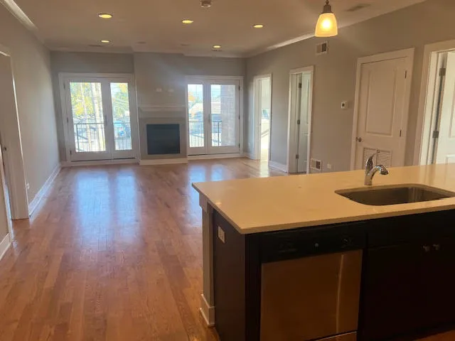 a kitchen with a sink cabinets and wooden floor