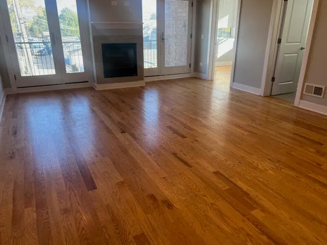 an empty room with wooden floor and fireplace
