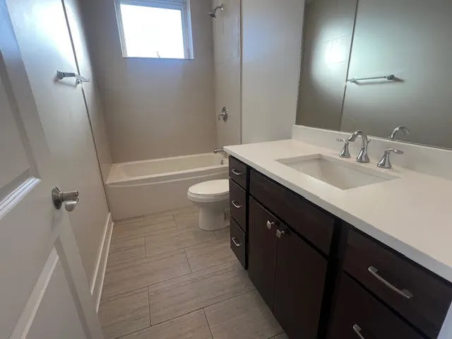 a bathroom with a sink a toilet a mirror and shower