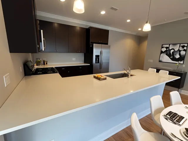 a kitchen with a sink a stove and chairs