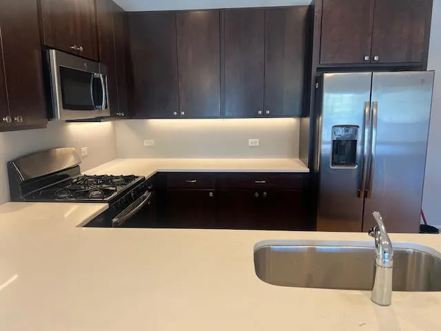 a kitchen with granite countertop a refrigerator and a stove