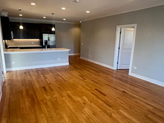 a view of a big room with wooden floor and a large window